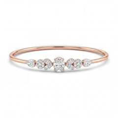 Elegant 18KT rose gold bangle featuring a central round solitaire diamond with pear-shaped side diamonds in a sleek minimalist design on a white background.