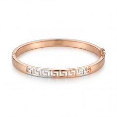 Elegant 18KT rose gold kada bracelet featuring white gold Greek key pattern detailing on a white background.