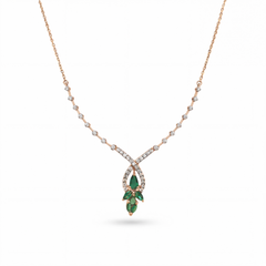 Beautiful 18KT rose gold necklace showcasing a sparkling diamond chain with teardrop pendant and green gemstone cluster on a white background.