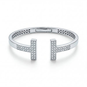 Elegant 18KT white gold open bangle featuring twin T-shaped diamond-studded ends on a white background.