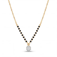 Elegant 18K gold mangalsutra necklace featuring black bead detailing and a sparkling diamond cluster pendant on a white background by Pachchigar Jewellers Ashokbhai.