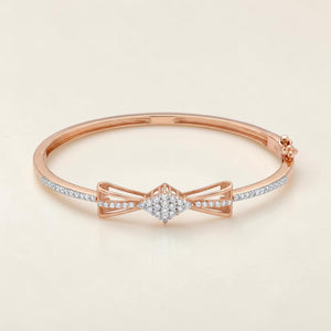 Elegant 18K rose gold diamond kada featuring a graceful bow motif, brilliant round diamond cluster centerpiece, and pavΓ©-set diamond accents. Luxury designer bracelet by Pachchigar Jewellers.