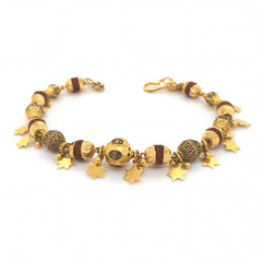 Stylish 22KT yellow gold bracelet featuring textured designer beads, decorative accents, and dangling star charms on a white background.