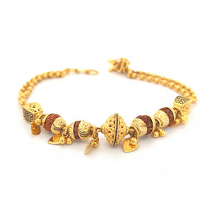 Elegant 22KT yellow gold bracelet featuring Rudraksha beads, ornate gold centerpiece, engraved accents, and dangling heart charms on a white background.