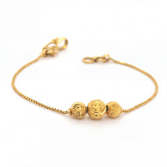 Elegant 22KT yellow gold bracelet featuring a delicate box chain with three textured gold bead accents on a white background.