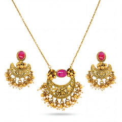 Traditional 22K yellow gold pendant set featuring antique filigree crescent design with oval ruby stones, pearl danglers, and matching chandbali earrings.