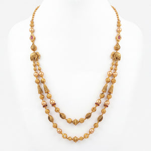 22K gold layered heritage necklace featuring lustrous pearls, ruby-colored stone accents, intricately textured gold beads, elephant motifs, and dual cascading strands, crafted for a regal and timeless traditional look.