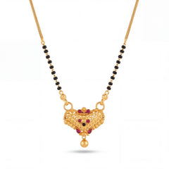 Traditional mangalsutra featuring black bead strands, handcrafted gold chain, ornate designer pendant with red stone embellishments, filigree detailing, and timeless ethnic styling for festive and bridal wear.