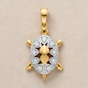 Yellow gold turtle-shaped pendant featuring a detailed shell design with white gold accents and embedded diamonds, symbolizing protection, longevity, and prosperity.