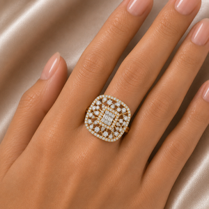 Elegant gold statement ring featuring a rounded rectangular face with a geometric lattice pattern, sparkling diamonds, and a prominent rectangular center diamond.