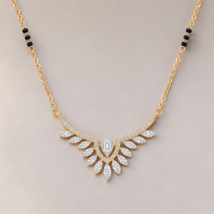 Elegant gold mangalsutra necklace featuring black beads and a dazzling diamond leaf wing pendant with a central emerald-cut diamond on a white background.