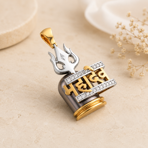 Gold and silver-tone pendant featuring a Trishul, the Hindi inscription “Har Har Mahadev,” and diamond-studded accents, finished with a gold bail.