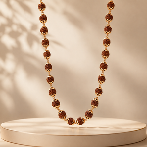 Elegant gold necklace featuring textured Rudraksha beads with delicate gold connectors and ornate bead caps, arranged in a graceful long necklace design.