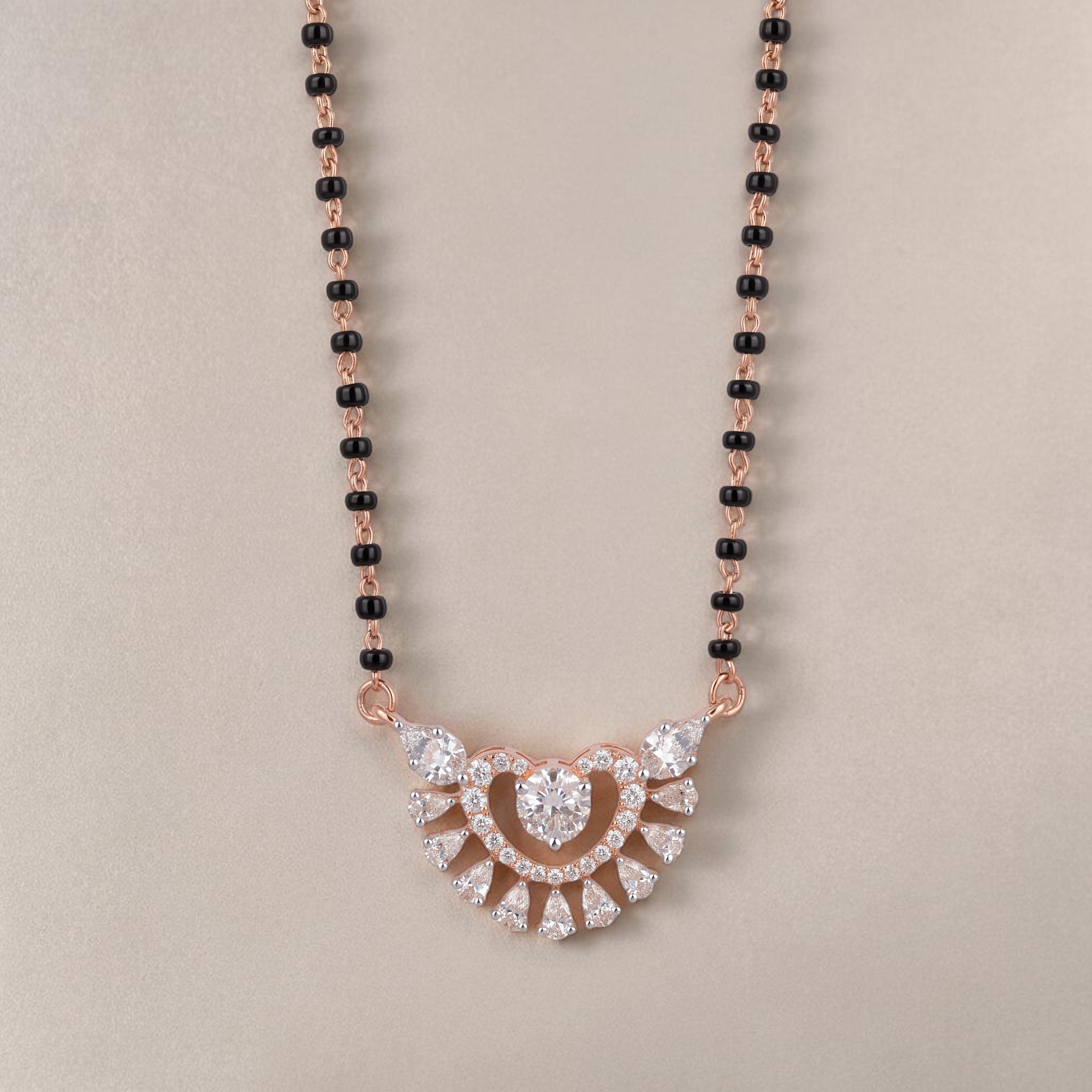 Elegant rose gold mangalsutra necklace featuring black beads and a sparkling heart-shaped floral diamond pendant with intricate detailing on a white background.