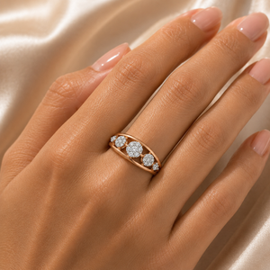 Elegant rose gold ring featuring three round diamond clusters arranged across a smooth curved band, accented with smaller diamonds for a delicate and sophisticated finish.