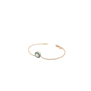 Elegant rose gold bracelet featuring a solitaire crystal centerpiece with turquoise enamel detailing on a delicate chain and adjustable clasp against a white background.
