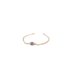 Elegant two-tone gold bracelet featuring a blue enamel centerpiece with textured gold beads on a delicate dual-chain design with adjustable clasp.