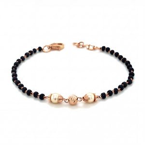 Elegant 18KT rose gold bracelet featuring black beads with pearl accents and textured gold centerpiece on a white background.