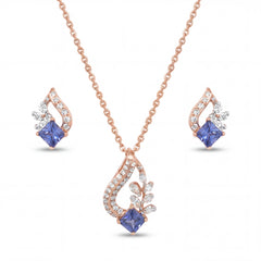 Elegant 18KT rose gold pendant set featuring blue princess-cut gemstone pendant with diamond accents and matching earrings on a white background.