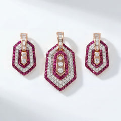 Elegant 18KT rose gold pendant set featuring a geometric hexagonal design adorned with vibrant ruby gemstones and brilliant round diamonds. The set includes a matching pendant and a pair of earrings with concentric ruby and diamond halos, creating a bold and contemporary statement.