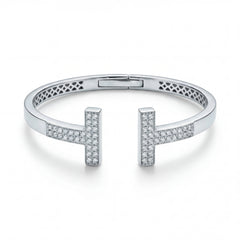 Elegant 18KT white gold open bangle featuring twin T-shaped diamond-studded ends on a white background.