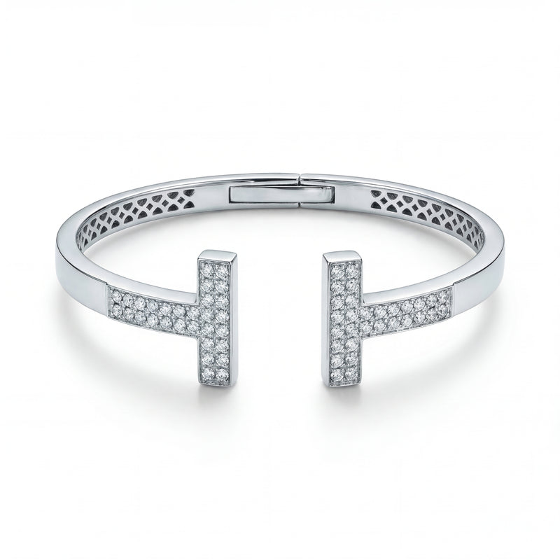 Elegant 18KT white gold open bangle featuring twin T-shaped diamond-studded ends on a white background.