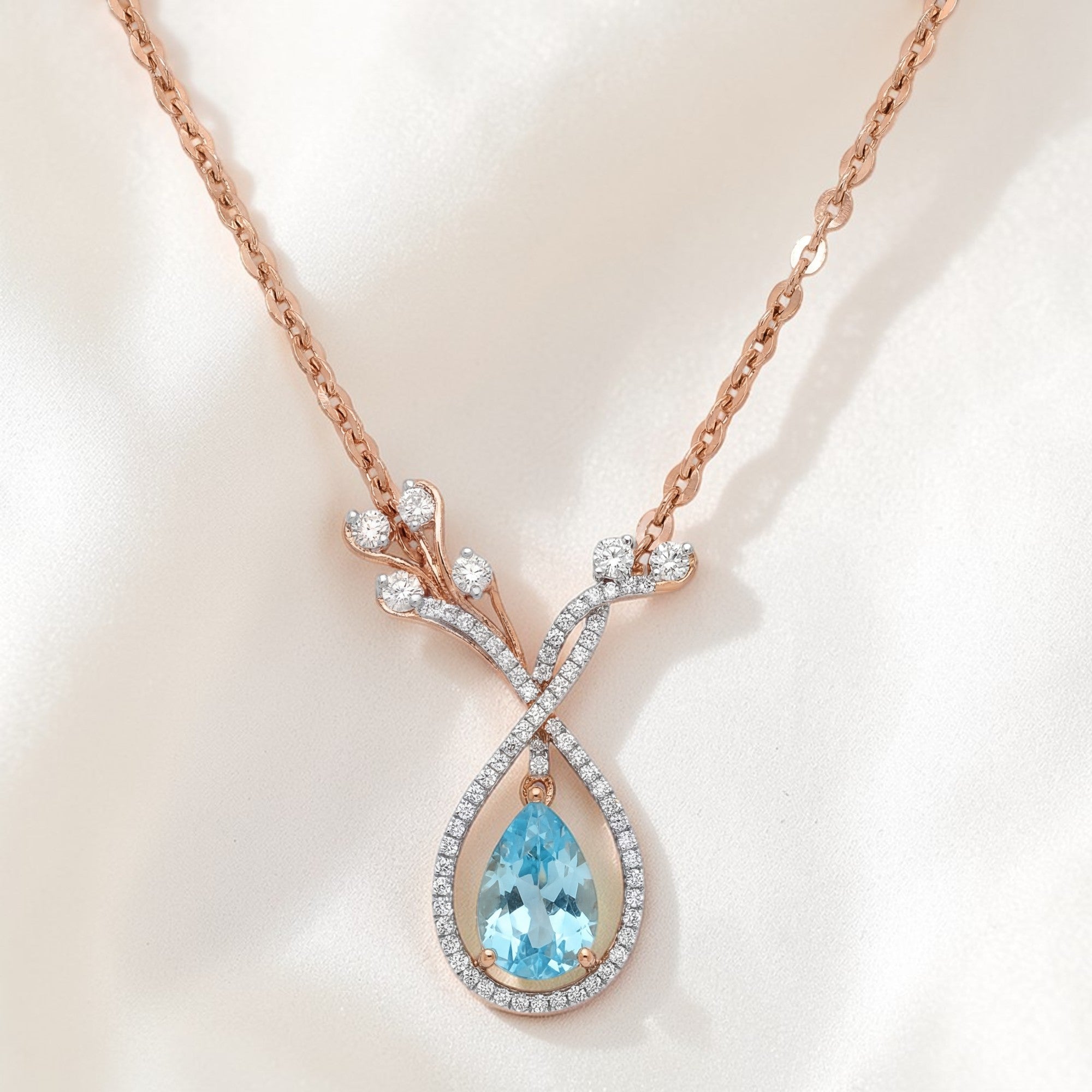 Luxurious 18K rose gold aquamarine diamond designer pendant necklace featuring pear shaped blue gemstone with diamond leaf inspired drop setting by Pachchigar Jewellers Ashokbhai