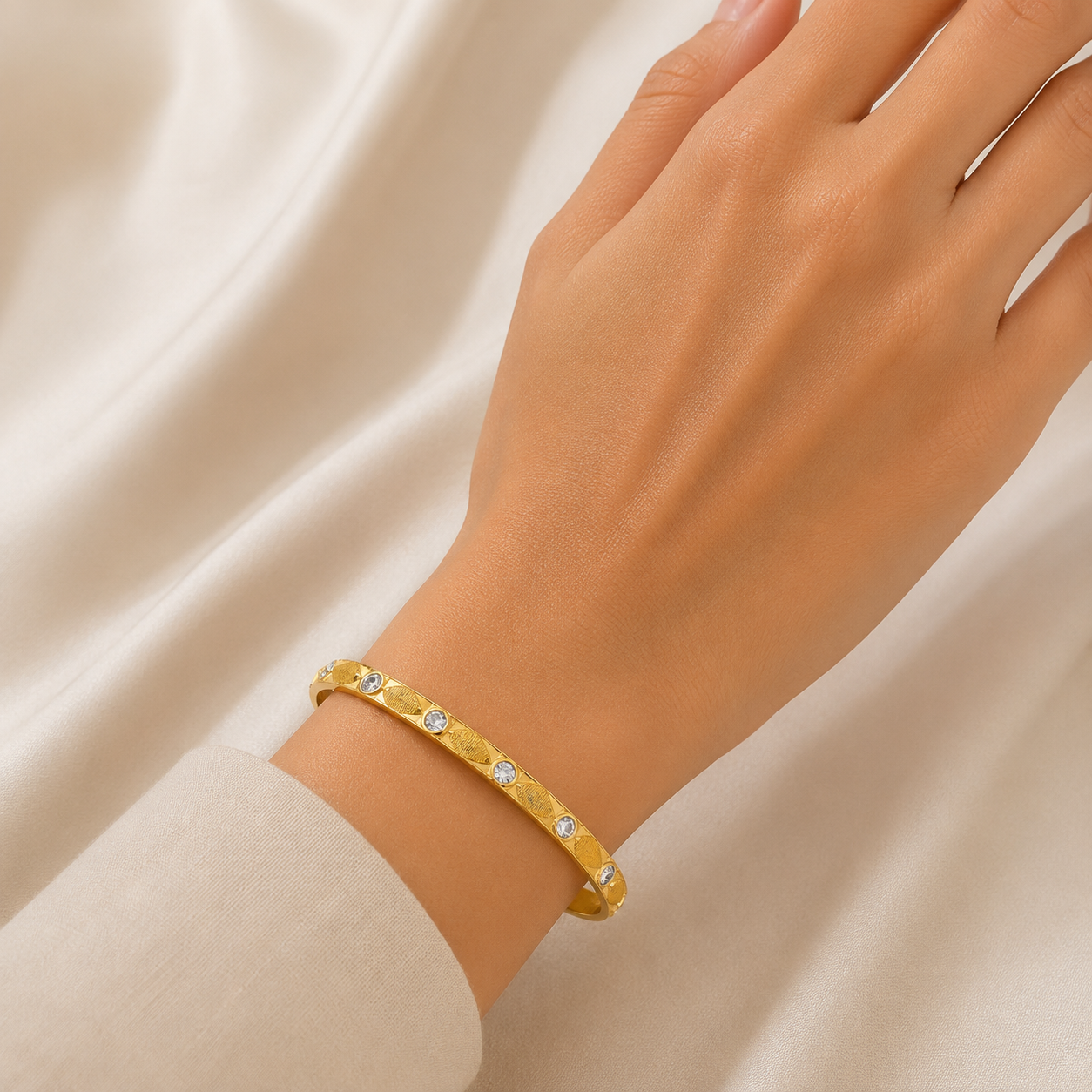 Elegant 18K yellow gold designer bangle featuring bezel-set round brilliant diamonds, engraved geometric facets, a sleek polished finish, and a contemporary minimalist design. Luxury diamond bracelet by Pachchigar Jewellers.