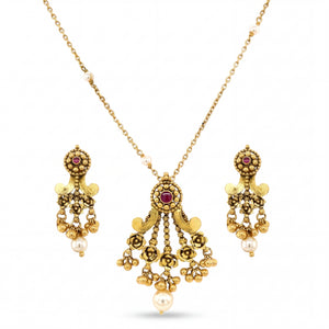 Graceful 22KT yellow gold pendant set featuring antique-style pendant with ruby accents, floral detailing, pearl drops, and matching dangling earrings on a white background.