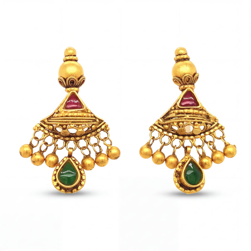 Elegant 22KT yellow gold jhumka earrings featuring ruby triangle accents, emerald teardrop danglers, and hanging gold bead charms on a white background.