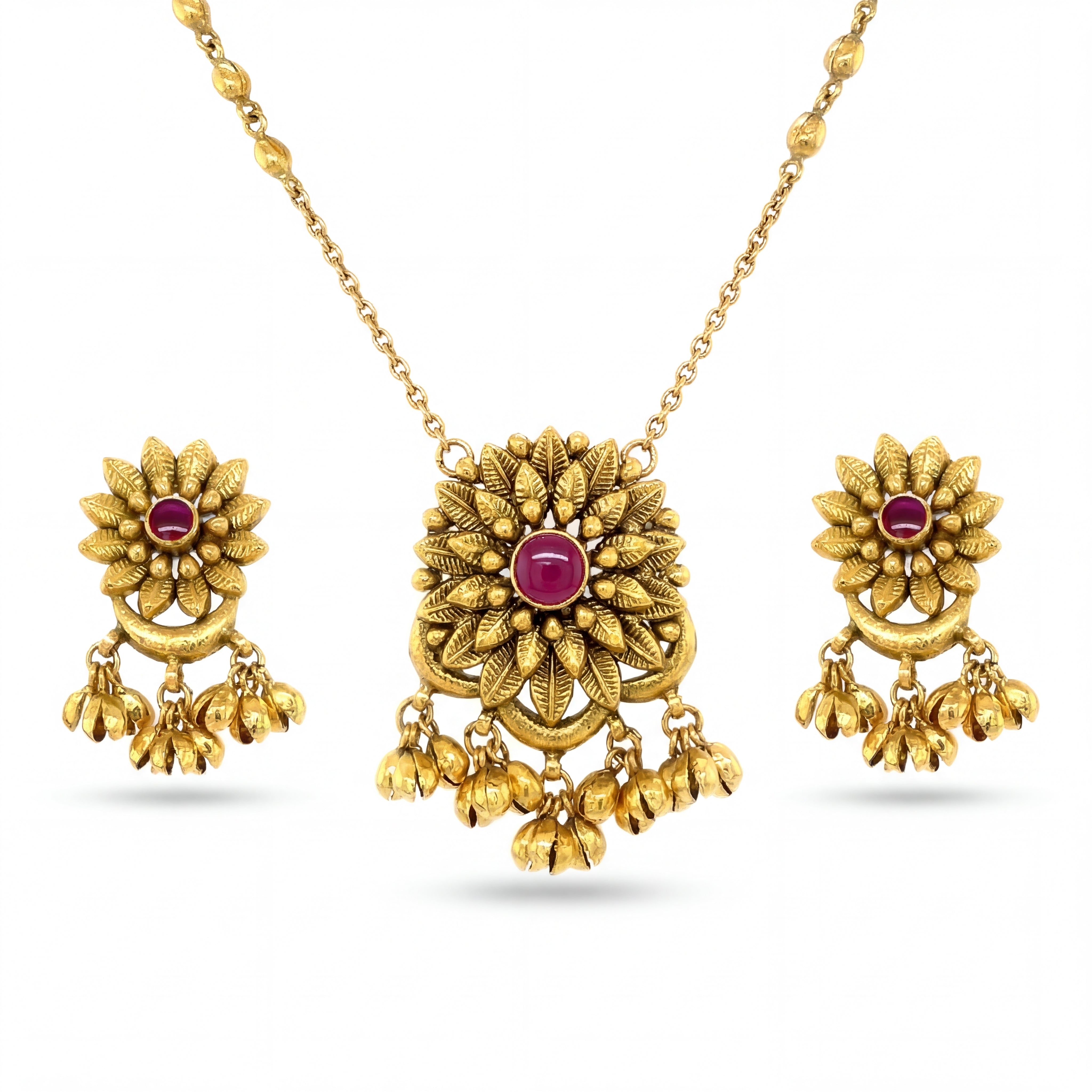 Beautiful 22KT yellow gold pendant set featuring floral motif pendant with ruby center stone, dangling gold bead charms, and matching earrings on a white background.