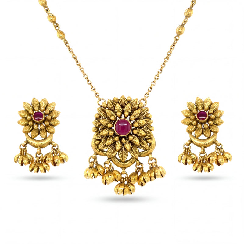 Beautiful 22KT yellow gold pendant set featuring floral motif pendant with ruby center stone, dangling gold bead charms, and matching earrings on a white background.