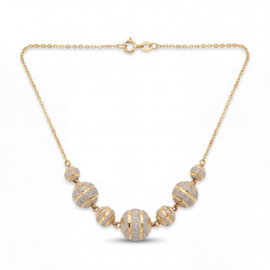 Elegant 22KT yellow gold necklace featuring graduated round beads with sparkling textured stripe detailing on a delicate chain against a white background.