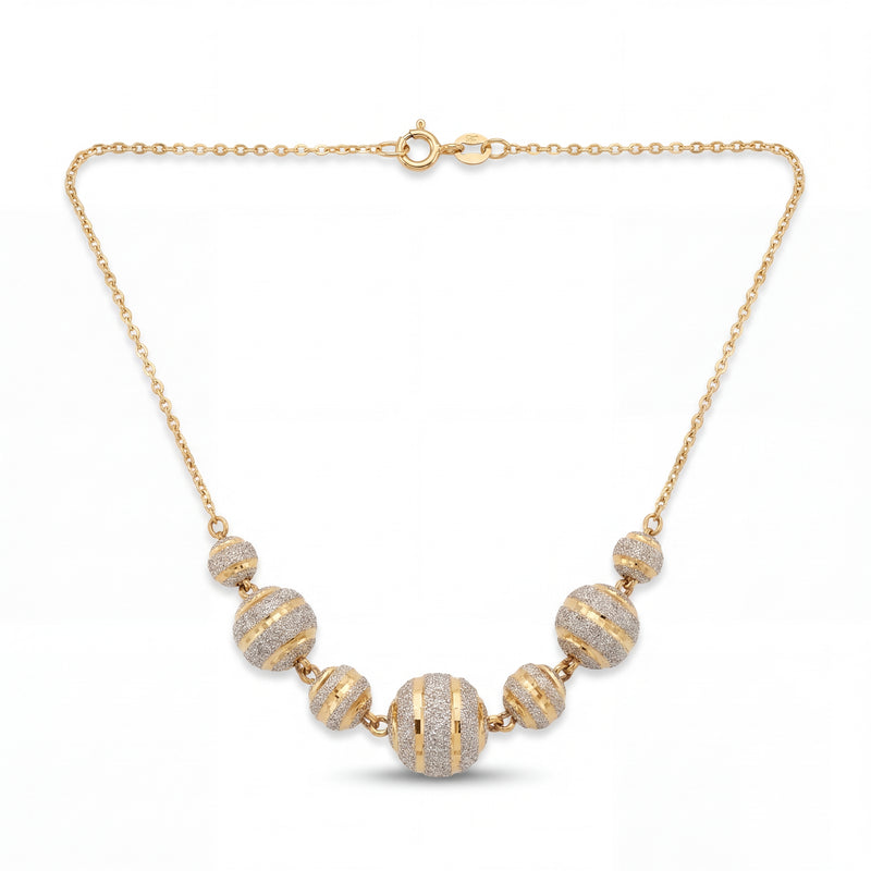 Elegant 22KT yellow gold necklace featuring graduated round beads with sparkling textured stripe detailing on a delicate chain against a white background.