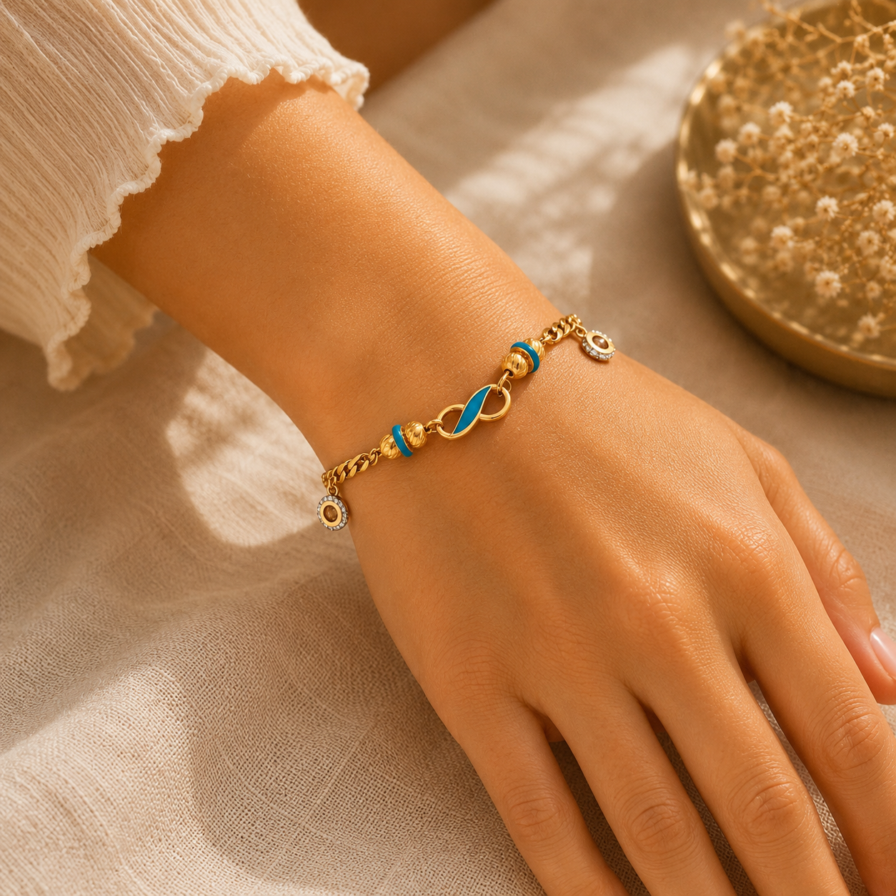 Elegant 22KT yellow gold bracelet featuring a turquoise enamel infinity-inspired centerpiece with evil eye charm accents and a stylish curb chain, beautifully worn on a woman's wrist, perfect for everyday wear, gifting, and symbolic protection.