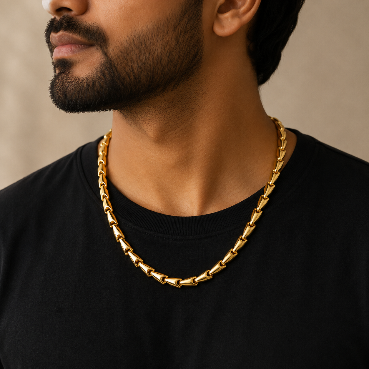 Man wearing a 22K gold chevron link chain featuring polished V-shaped interlocking links with a sleek contemporary finish, styled with a black t-shirt for a bold and refined everyday look.