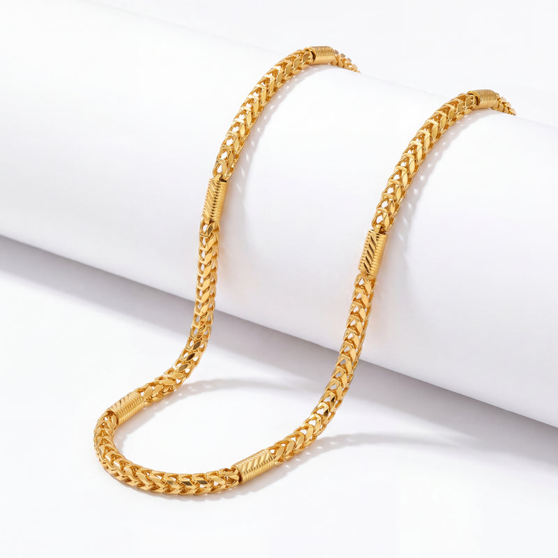 Elegant 22K yellow gold fancy link chain necklace with textured detailing displayed on a white cylindrical stand.