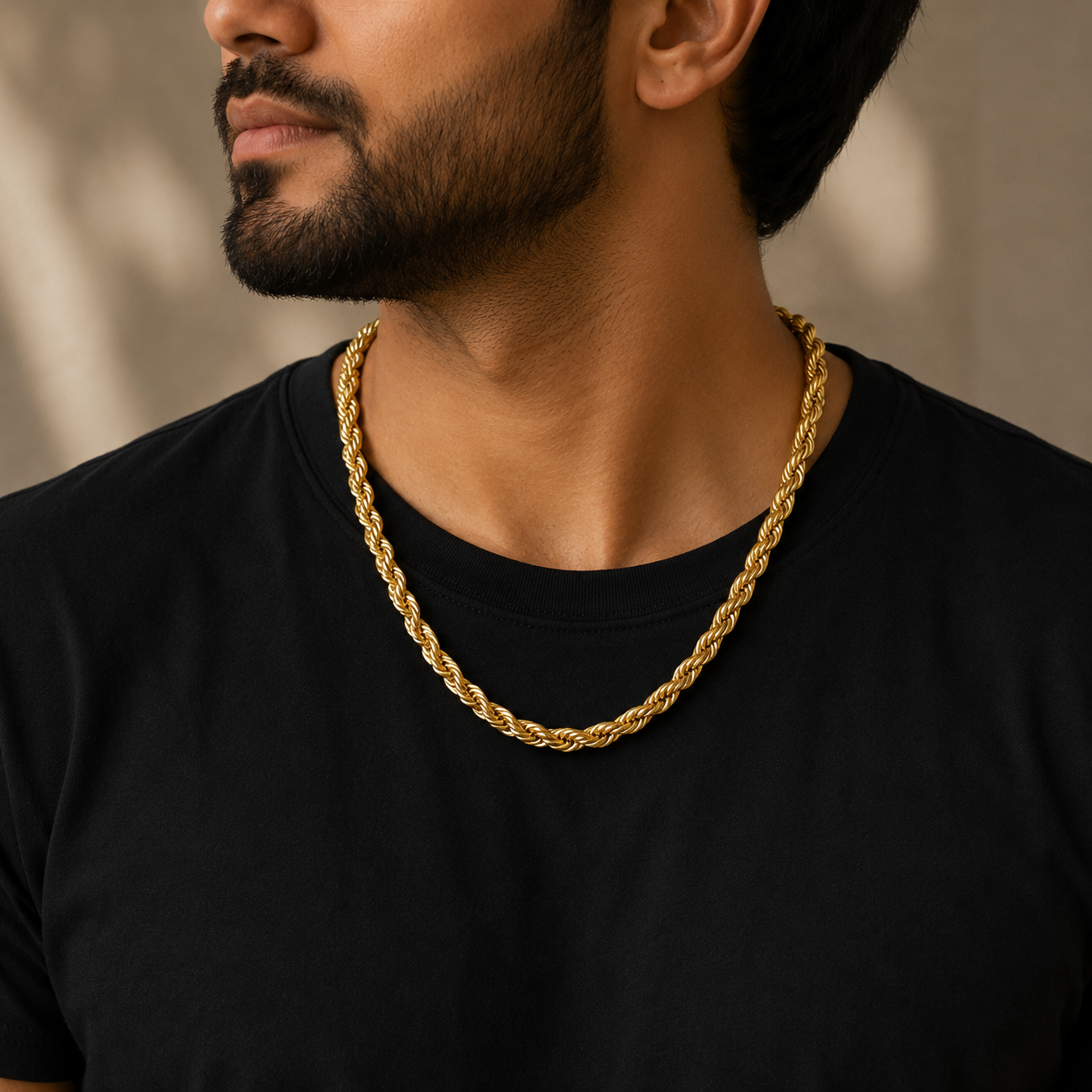 Man wearing a 22K gold twisted rope chain featuring intricately woven spiral links with a polished finish, paired with a black t-shirt for a timeless and sophisticated everyday look.