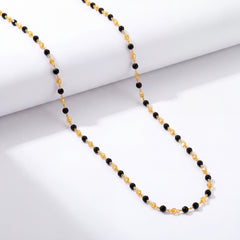 Elegant gold chain featuring evenly spaced black beads connected by delicate gold links, creating a simple and refined design.