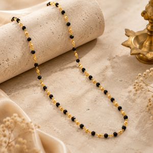 Elegant gold chain featuring evenly spaced black beads connected with delicate gold links, creating a minimal and refined design.