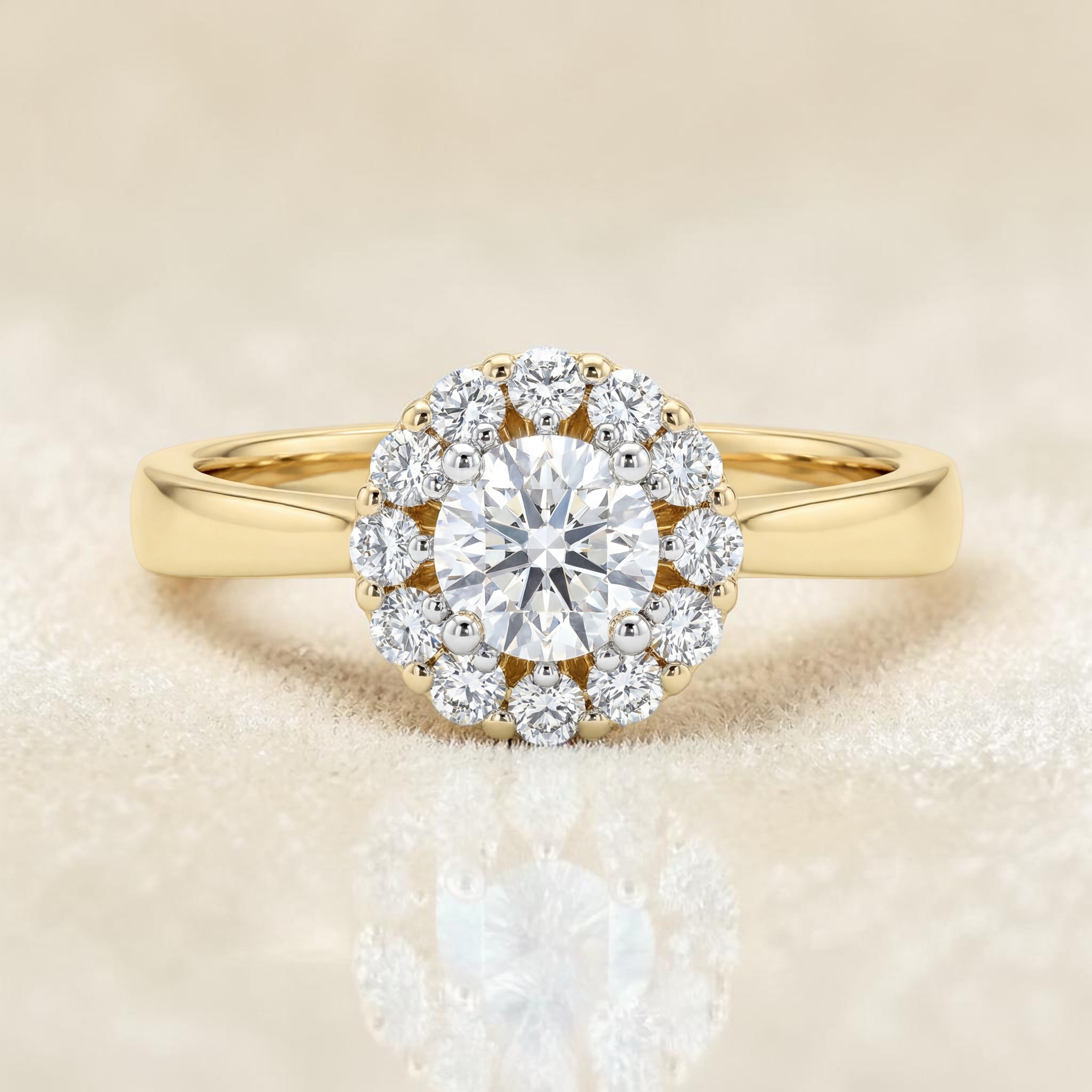 Yellow gold ring featuring a round brilliant solitaire diamond surrounded by a delicate halo of smaller diamonds, set on a sleek and minimal band for a timeless elegant look.