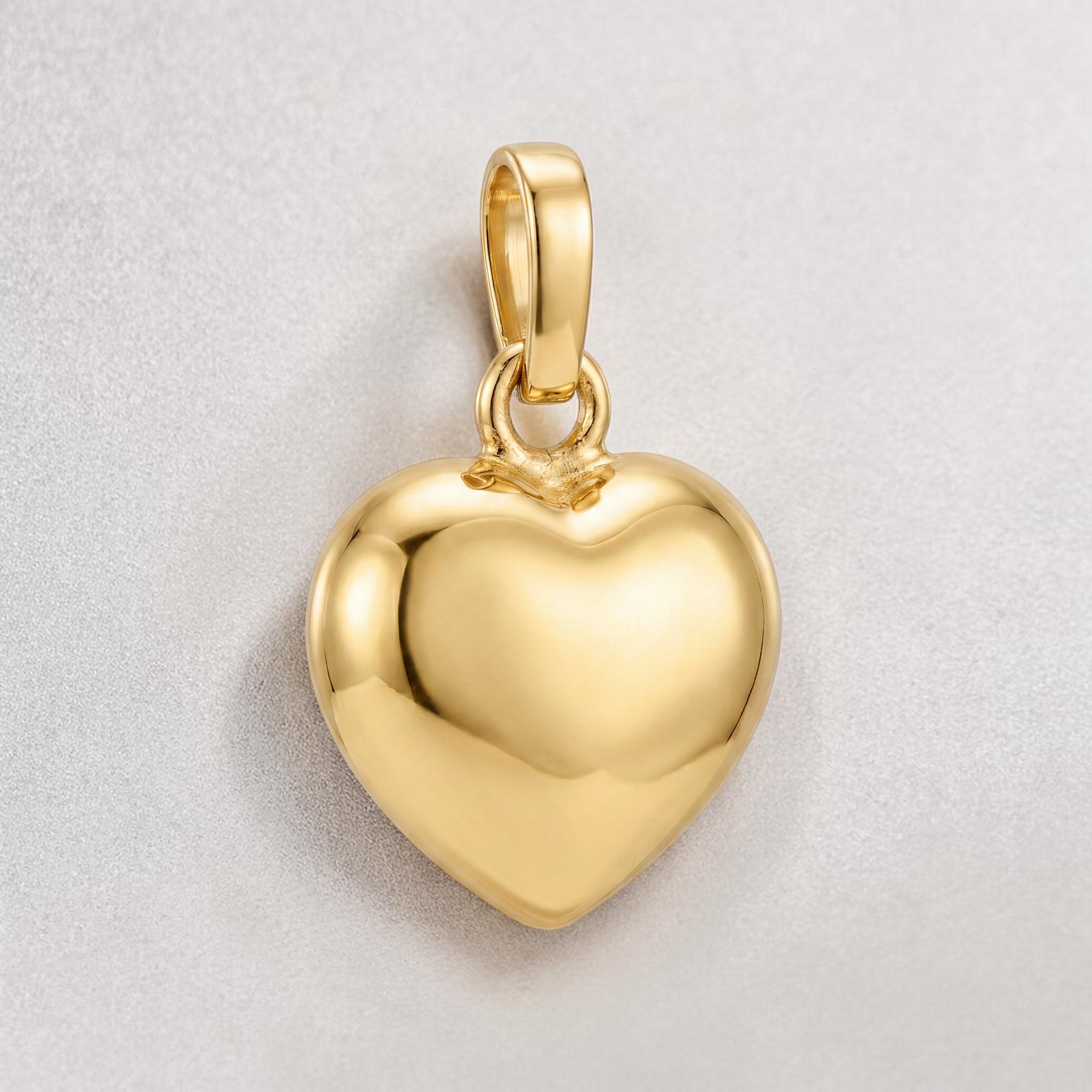 Polished yellow gold heart-shaped pendant with a smooth, high-shine finish, offering a timeless and elegant minimalist design.