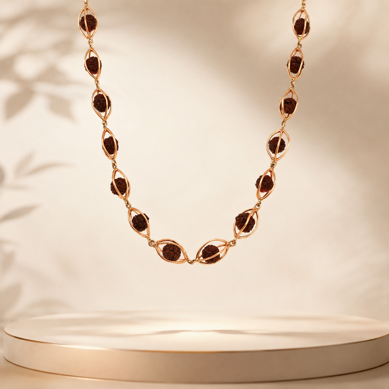 Elegant gold necklace featuring natural Rudraksha beads enclosed in delicate oval gold frames, connected with fine gold links in a graceful long-chain design.