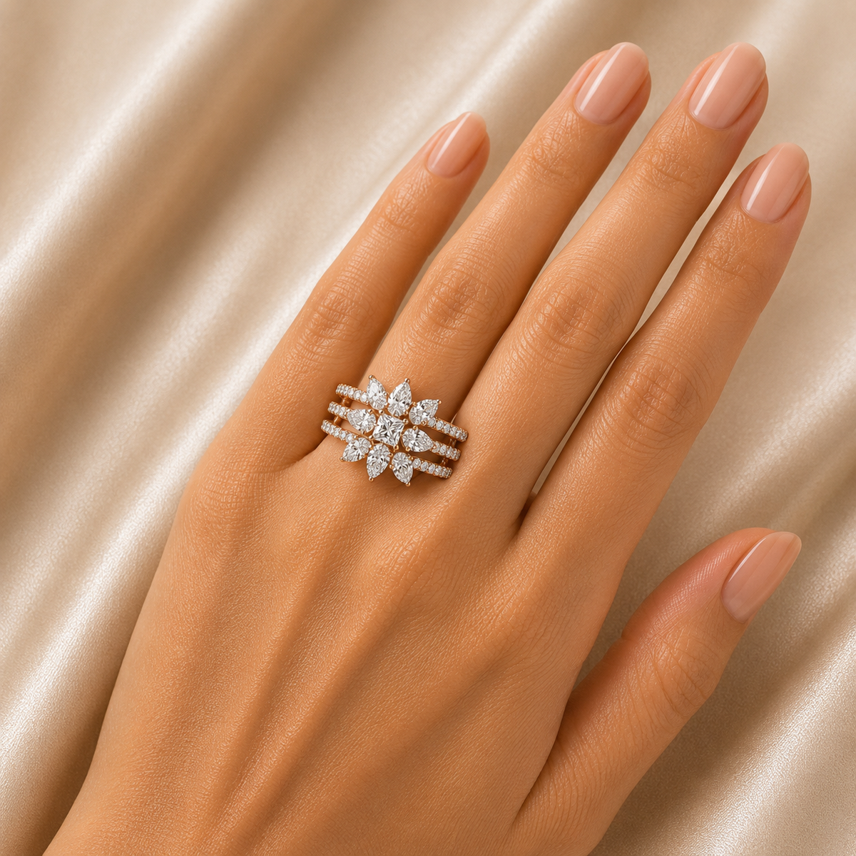 Elegant gold ring featuring a sparkling floral cluster of marquise-cut diamonds set across three delicate parallel bands, creating a graceful layered design.