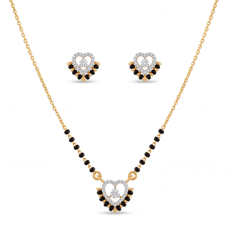 Elegant gold mangalsutra jewelry set featuring black beads, a heart-shaped diamond pendant, and matching heart stud earrings on a white background.