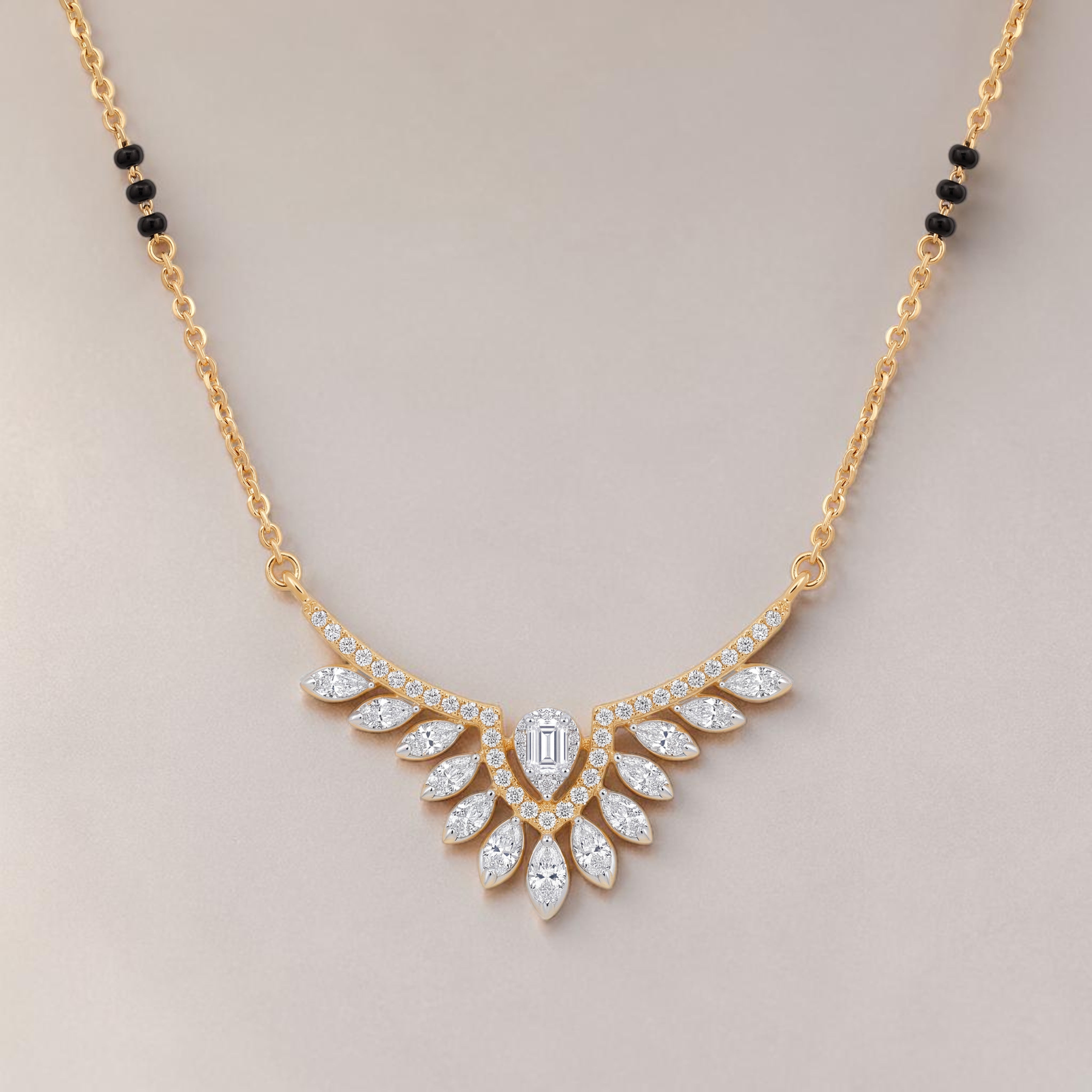 Elegant gold mangalsutra necklace featuring black beads and a dazzling diamond leaf wing pendant with a central emerald-cut diamond on a white background.