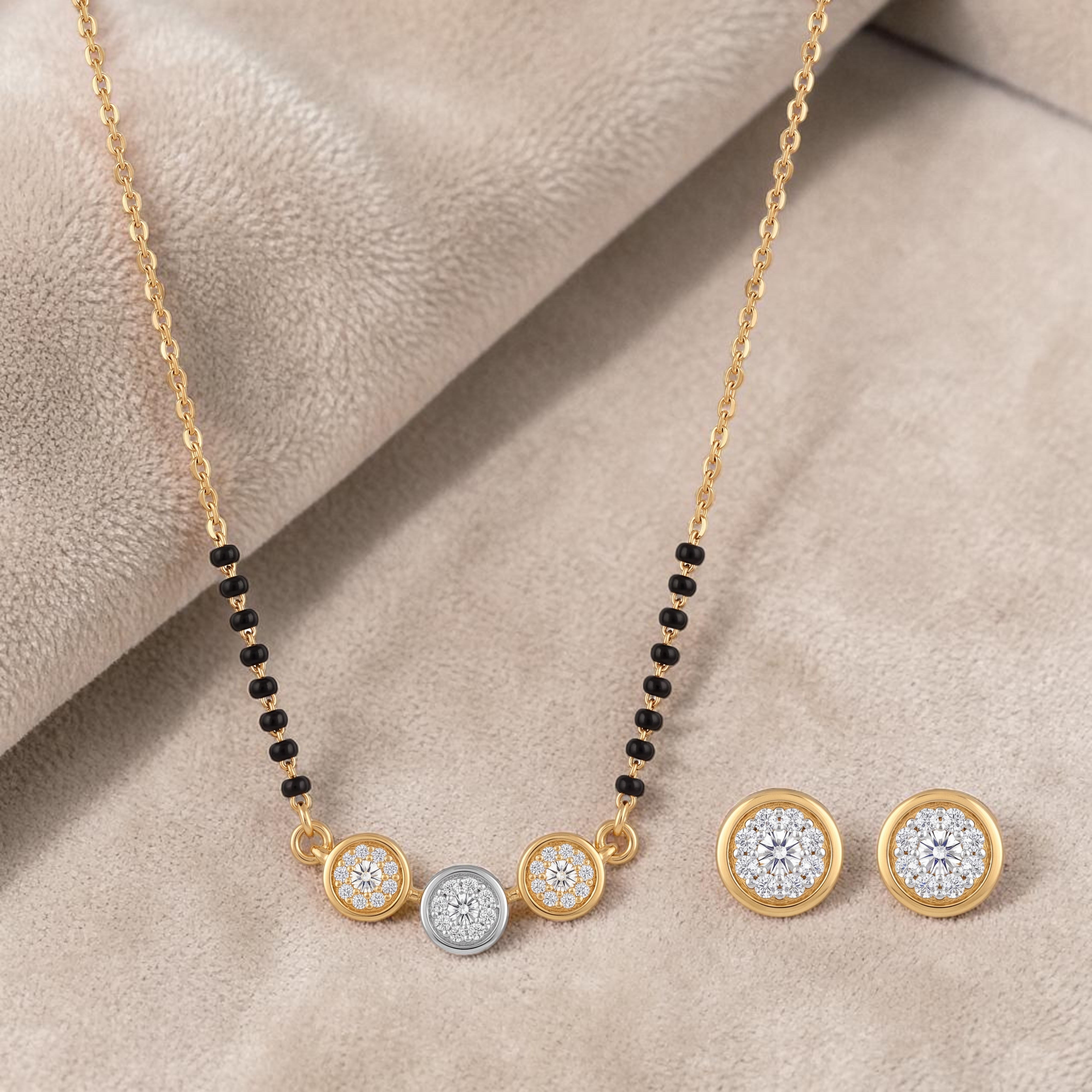 Elegant gold mangalsutra necklace featuring black beads, floral diamond motifs, and matching round diamond stud earrings on a white background.