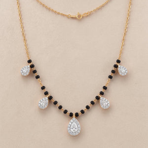 Elegant gold mangalsutra necklace featuring black beads and multiple sparkling teardrop-shaped diamond pendants on a white background.
