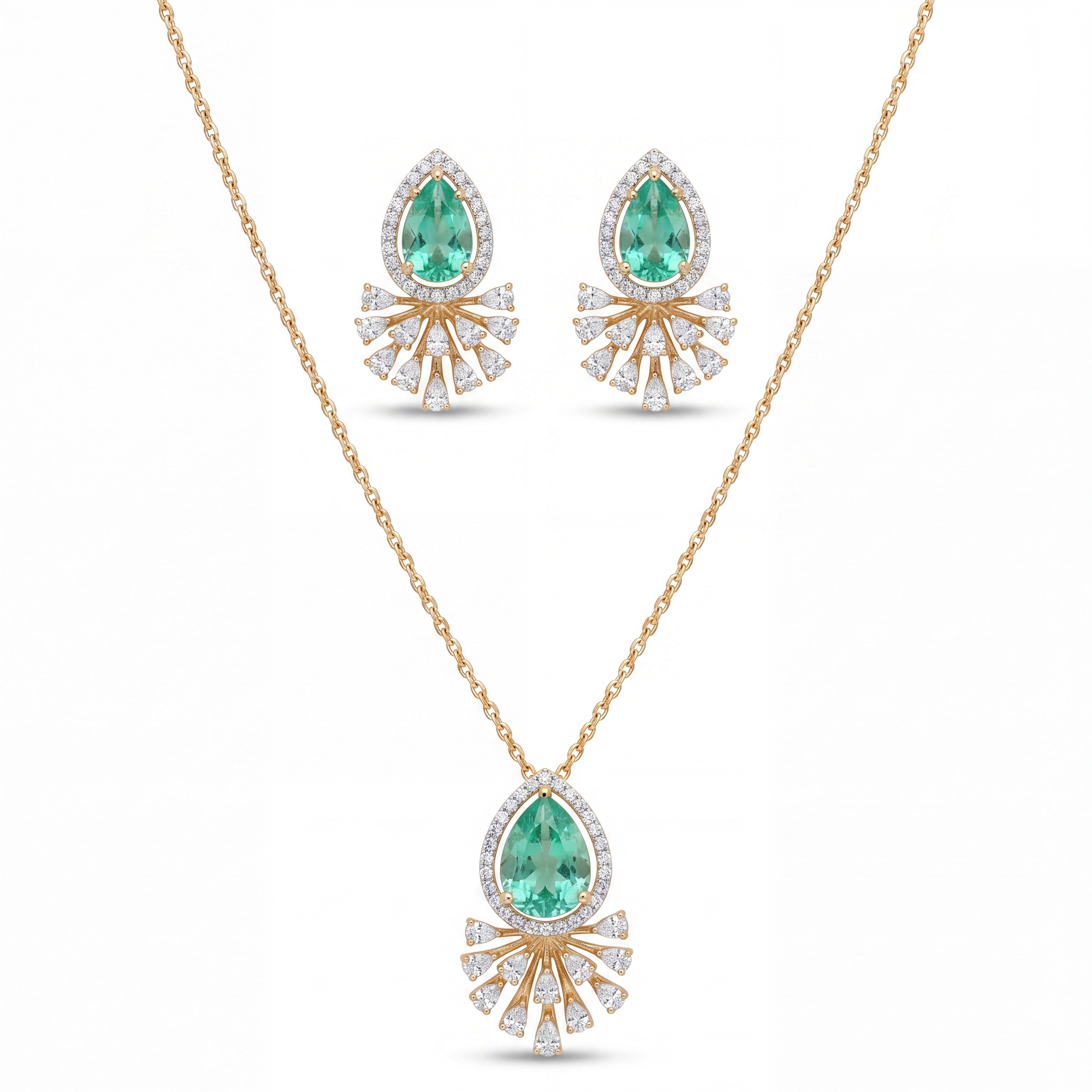 Elegant gold jewelry set featuring teardrop-shaped emerald gemstones with sparkling diamond halo detailing in a pendant necklace and matching earrings on a white background.