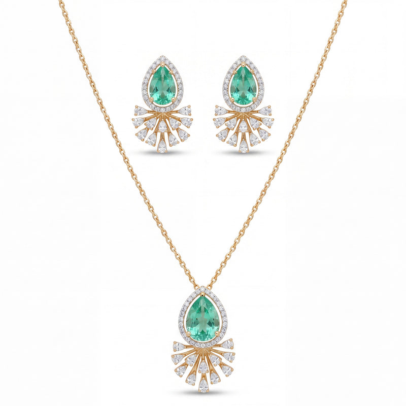 Elegant gold jewelry set featuring teardrop-shaped emerald gemstones with sparkling diamond halo detailing in a pendant necklace and matching earrings on a white background.